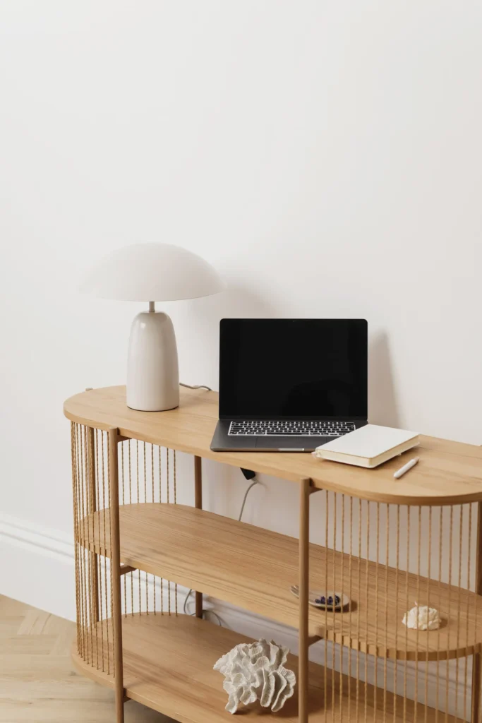 laptop and notebook on console table representing a structured content system workflow