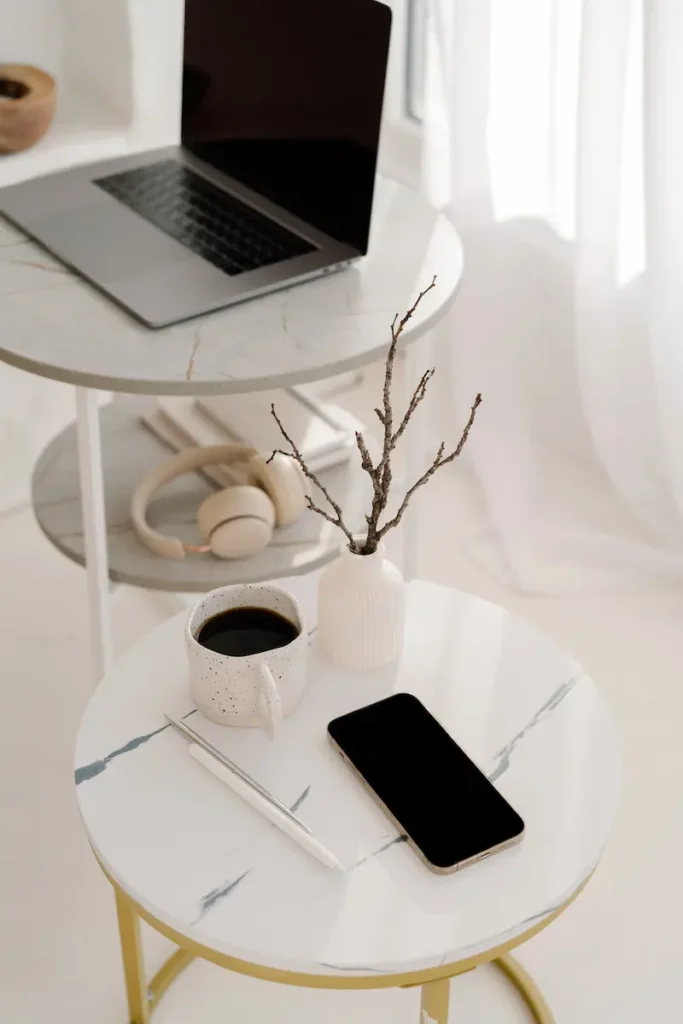 notebook, phone and coffee on desk representing building topical authority through content