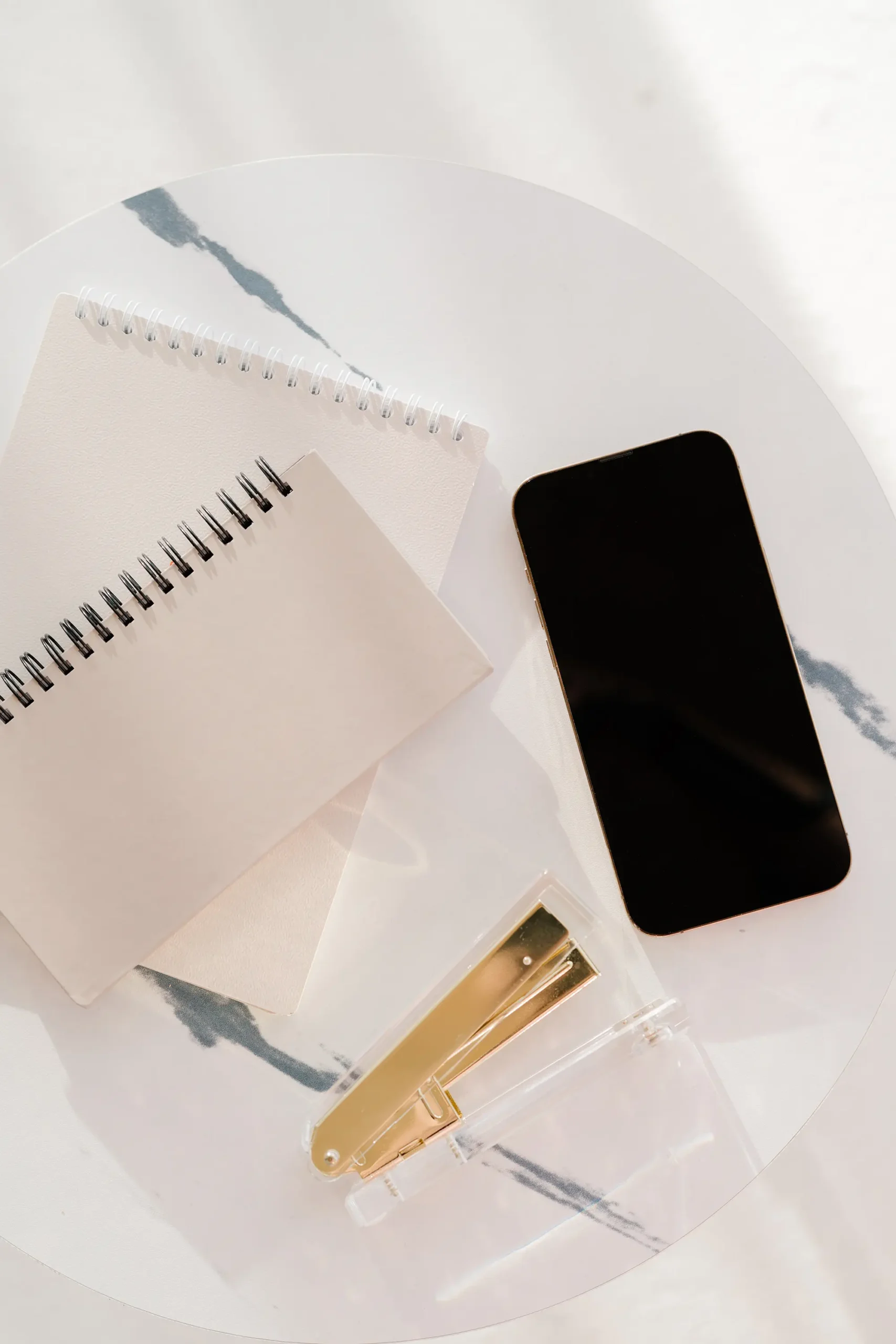 notebook and phone on desk representing AI-assisted content rewriting workflow