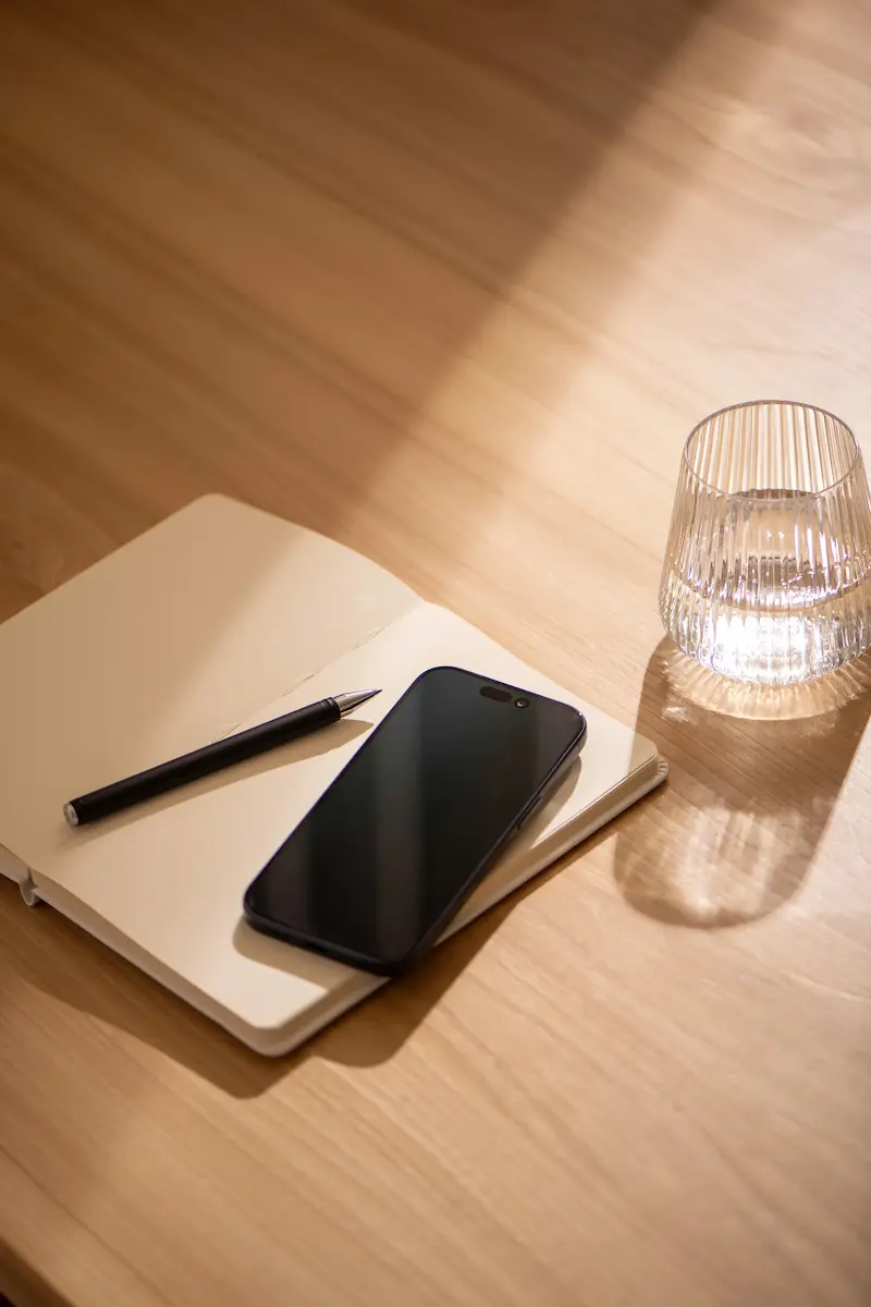 notebook and phone on wooden table used for blog flipping notes