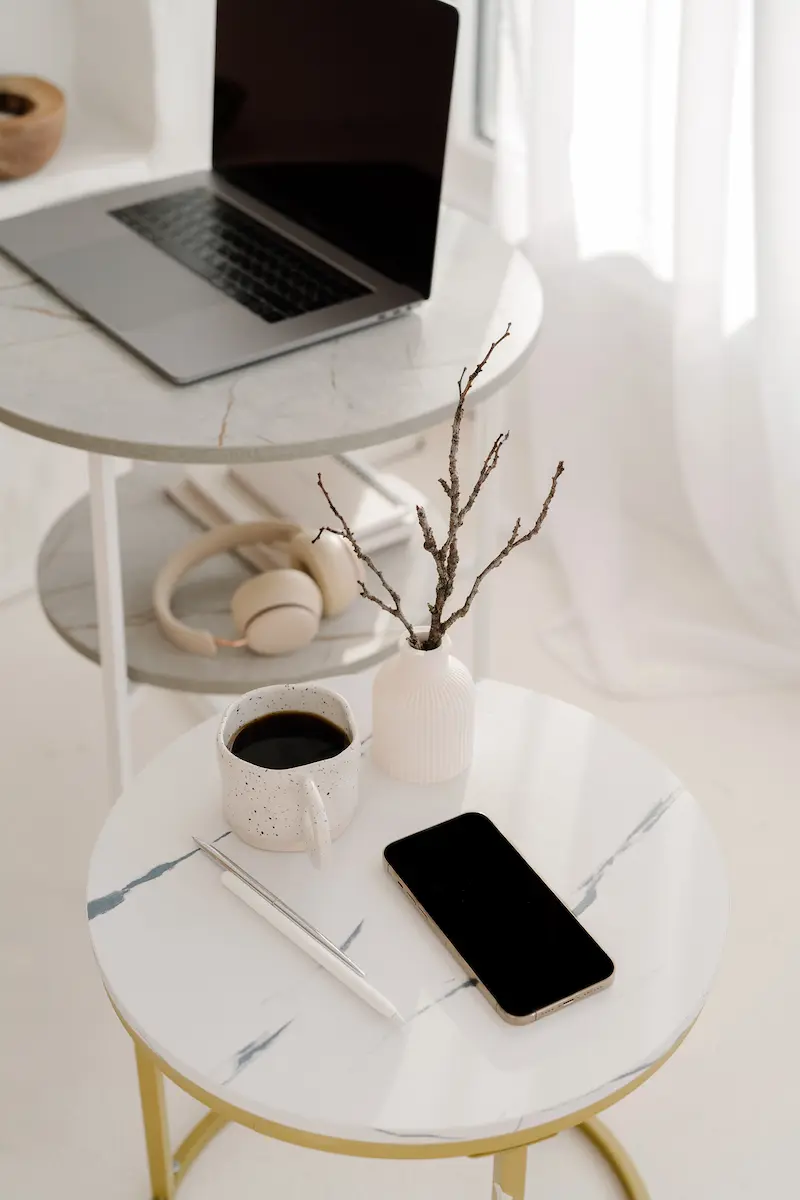 notebook, phone and coffee on desk representing building topical authority through content